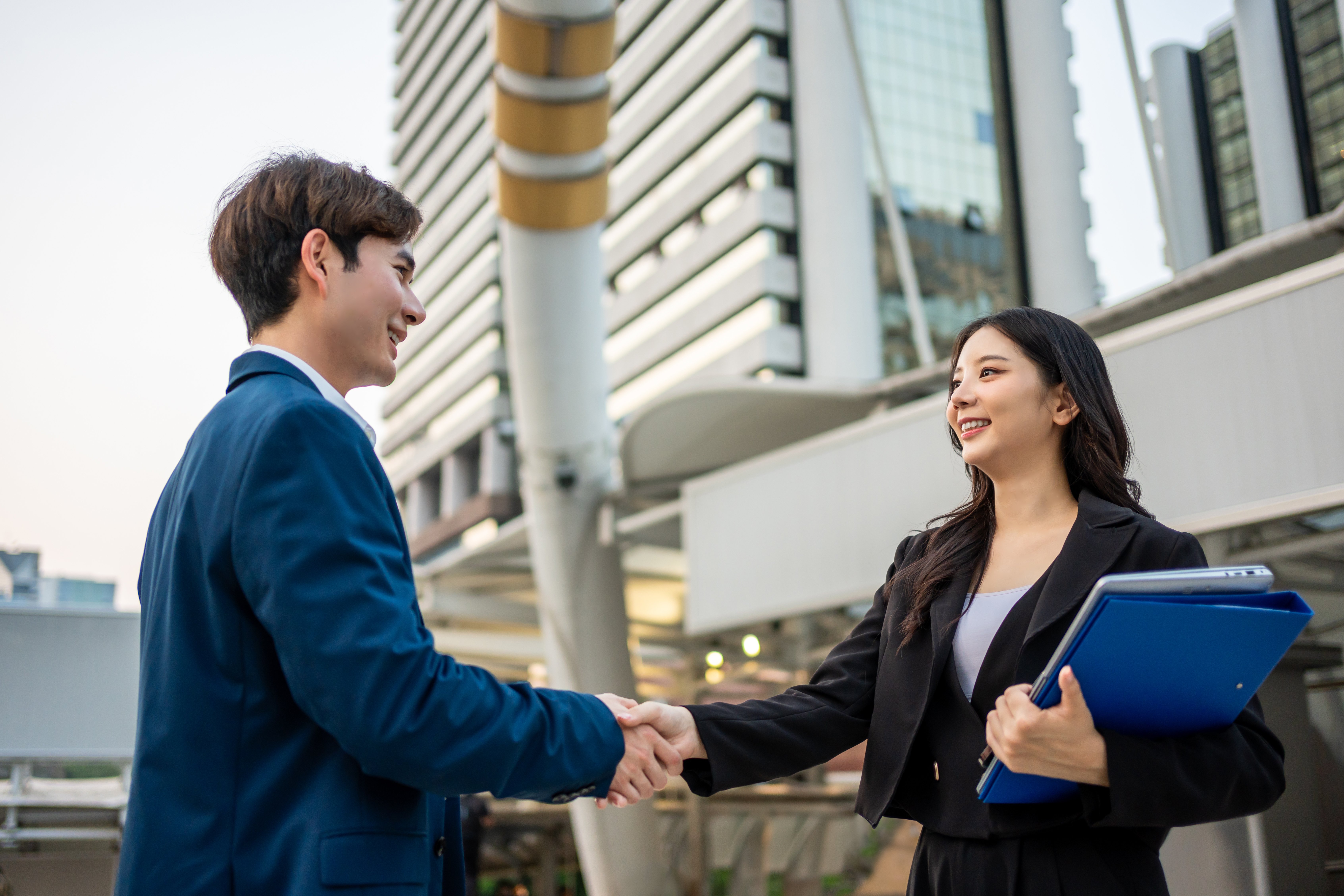 asian-businessman-and-woman-making-handshake-outdo-2026-03-24-22-44-27-utc