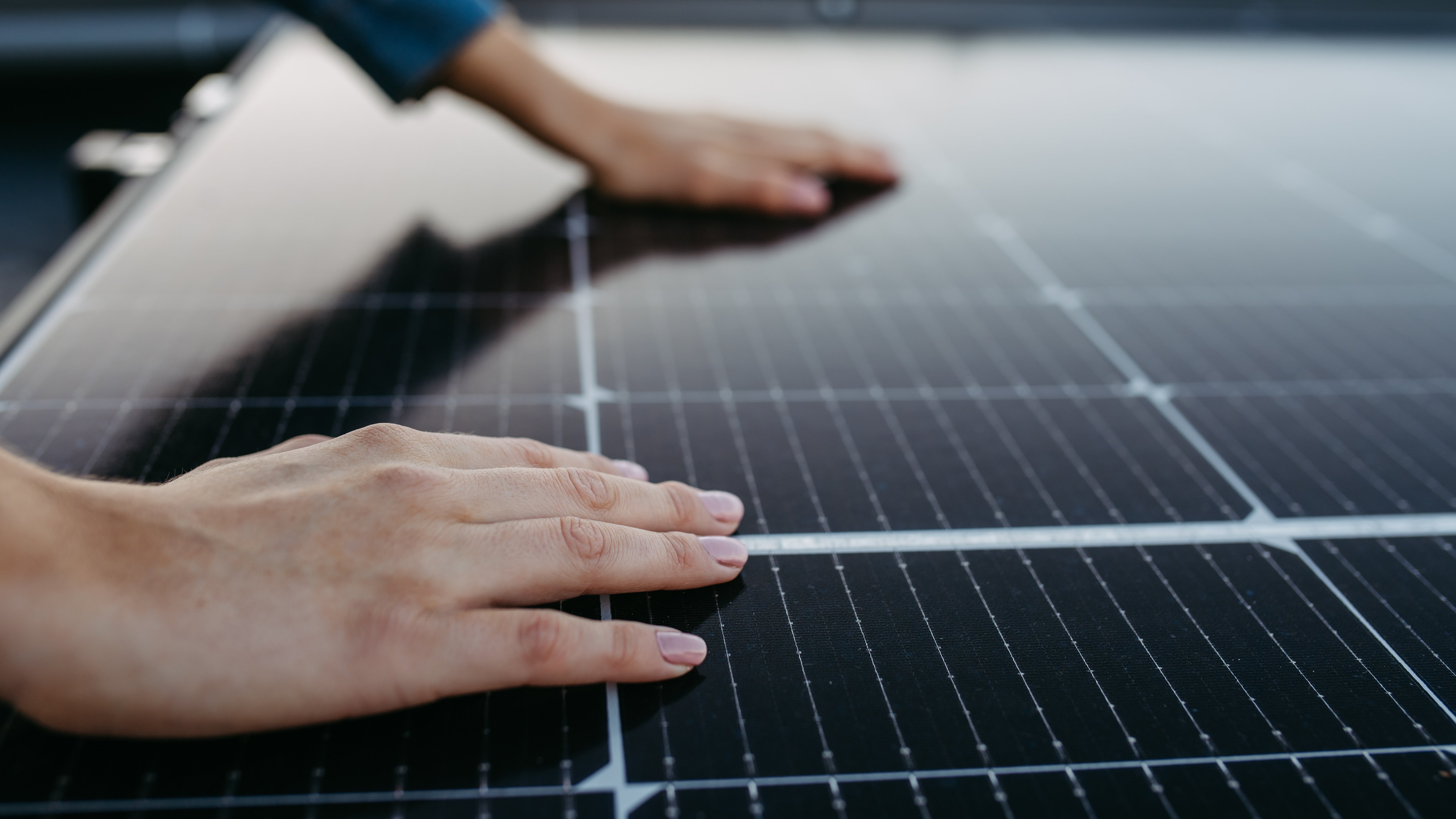 close-up-of-woman-touching-solar-panels-on-the-roo-2024-10-19-01-24-46-utc